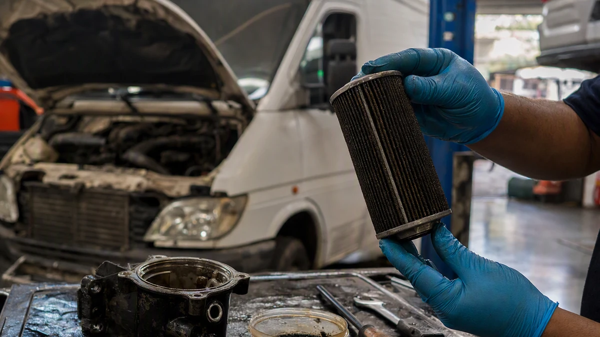Filtro de combustível diesel desmontado sobre bancada, com separador de água e resíduo visível